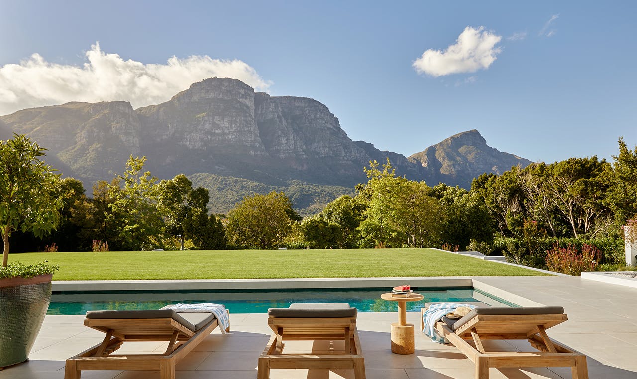 Outdoor pool terrace with sun loungers overlooking a mountain landscape